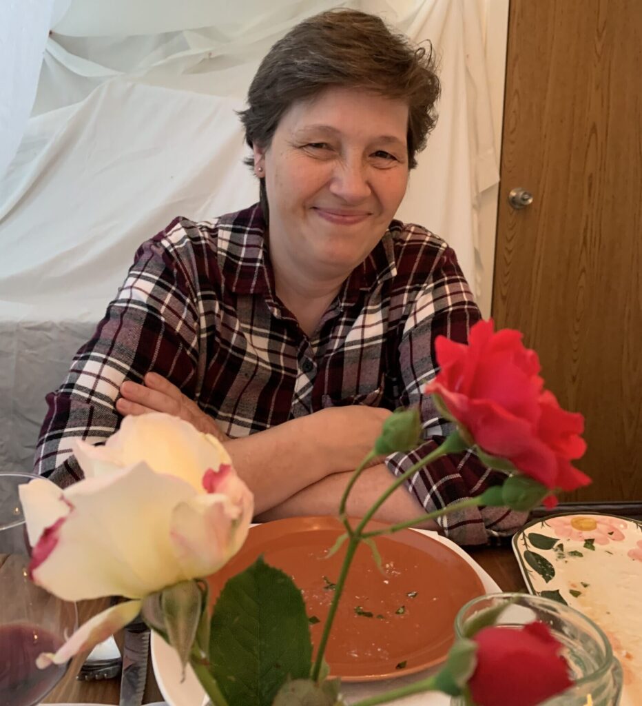 Debbie sitting on a table with plates