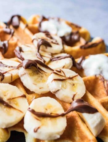 Waffle topped with banana slices, Nutella and whipping cream