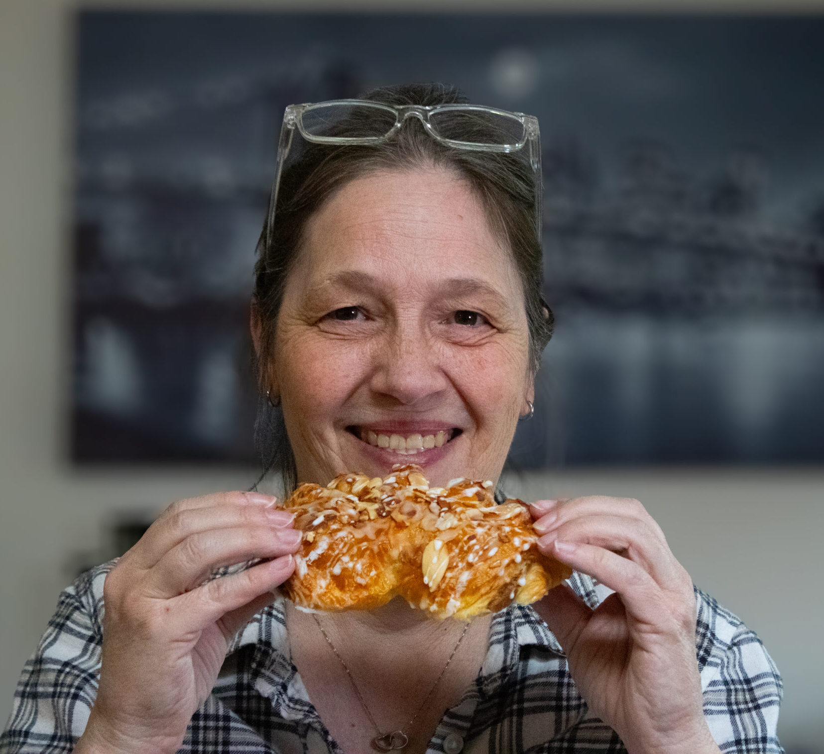 Debbie holding a bear claw and smiling