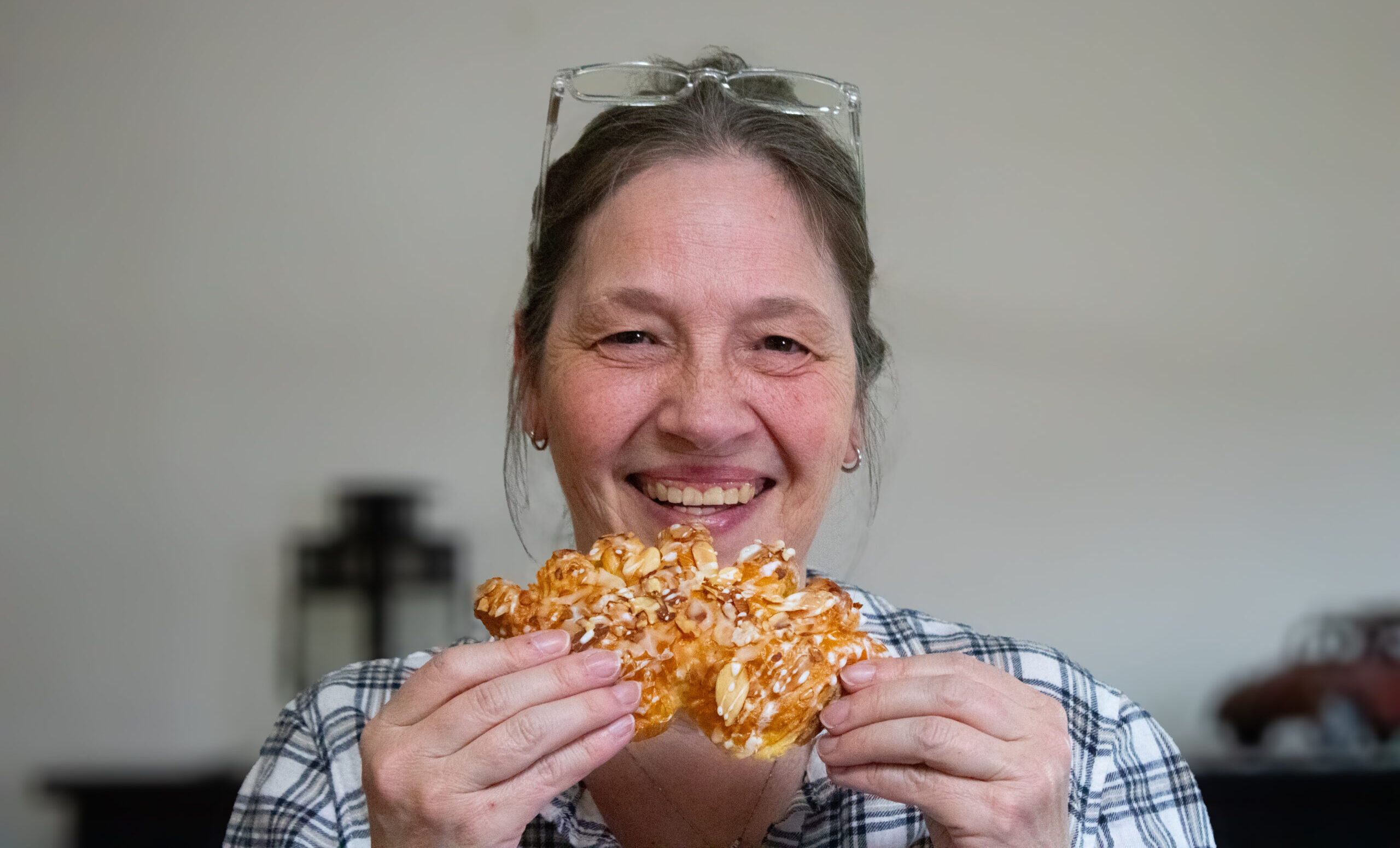 Debbie laughing holding bear claw pastry