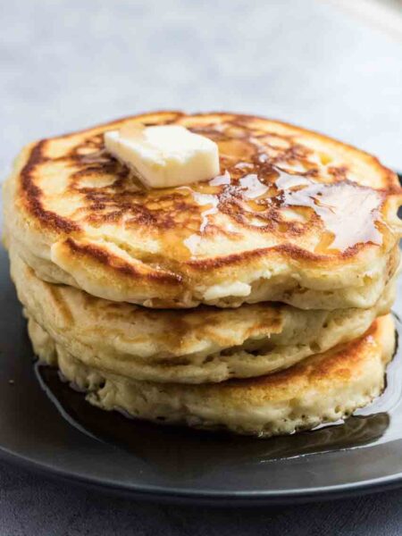 Stack of pancakes with butter and syrup on top