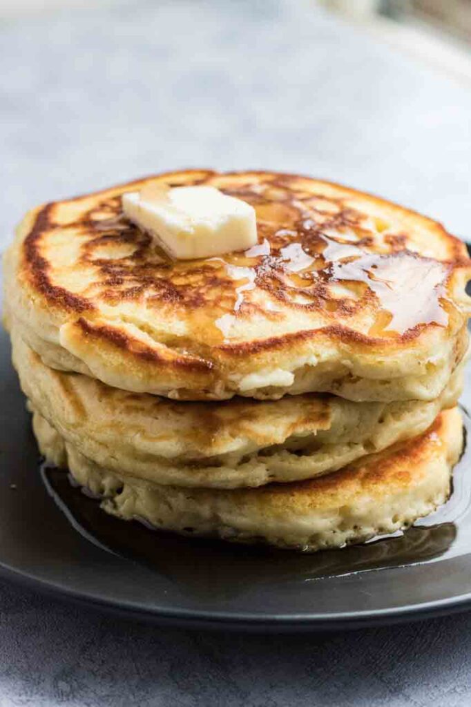 Stack of pancakes with butter and syrup on top