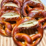 8 pretzels stacked up on a wooden cutting board