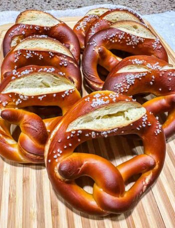 8 pretzels stacked up on a wooden cutting board