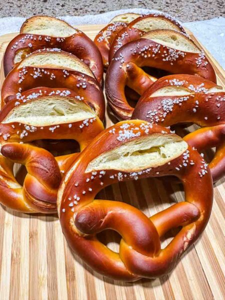 8 pretzels stacked up on a wooden cutting board