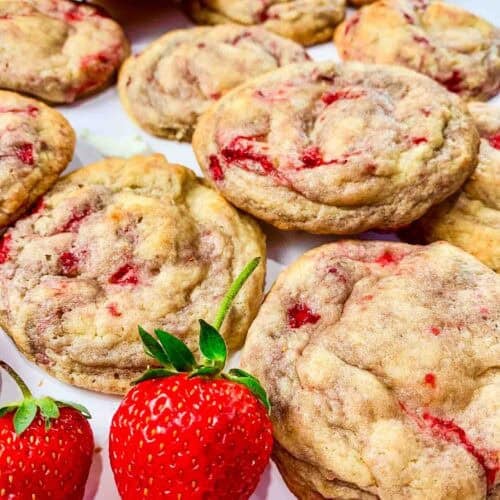 laid out strawberry cheesecake cookies with 2 whole strawberries