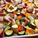 a sheet full of veggies and kielbasa sausage on top