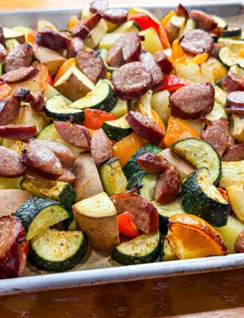 a sheet full of veggies and kielbasa sausage on top