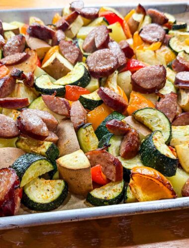 a sheet full of veggies and kielbasa sausage on top