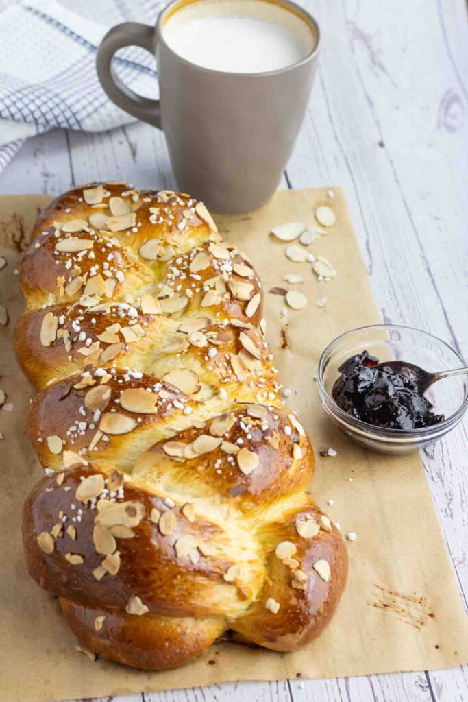 Hefezopf or German Sweet Bread with a cup of milk and a small bowl of marmalade