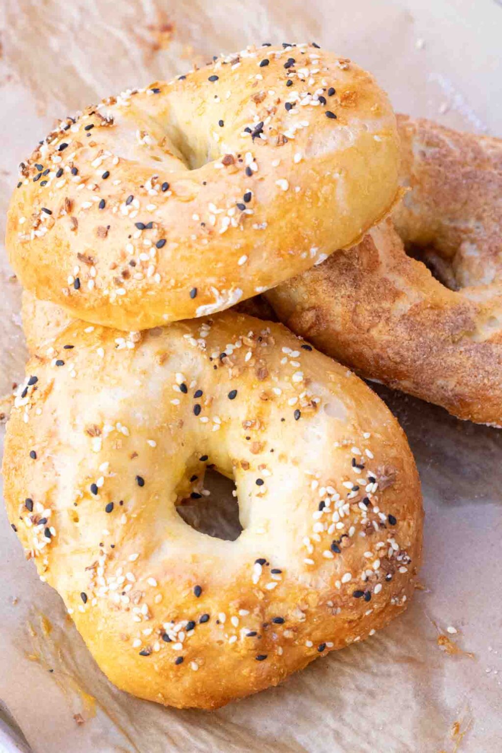 3 Healthy Greek Yogurt Protein Bagels on parchment paper with everything seasoning and cinnamon sugar.