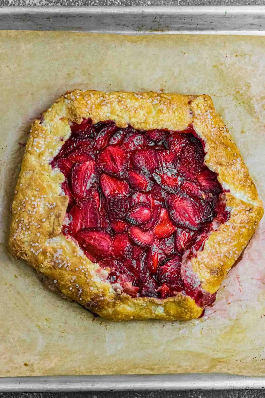 Golden brown Strawberry Galette on a brown parchment paper