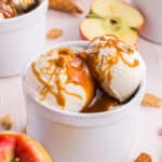 Apple Pie Ice Cream scoops in a white ramekin drizzled with caramel syrup