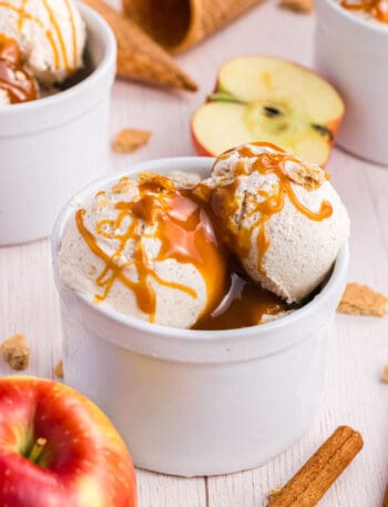 Apple Pie Ice Cream scoops in a white ramekin drizzled with caramel syrup