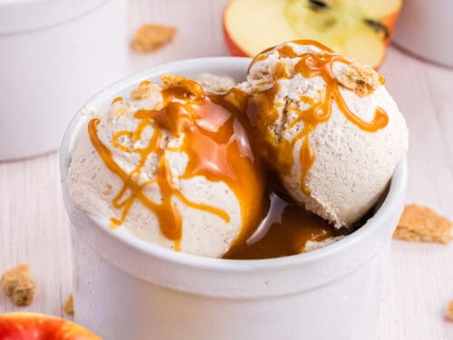 Apple Pie Ice Cream scoops in a white ramekin drizzled with caramel syrup