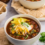 chilli topped with cheese in a white bowl