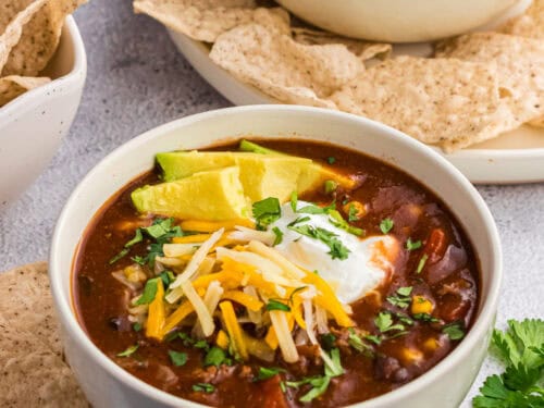 chilli topped with cheese in a white bowl