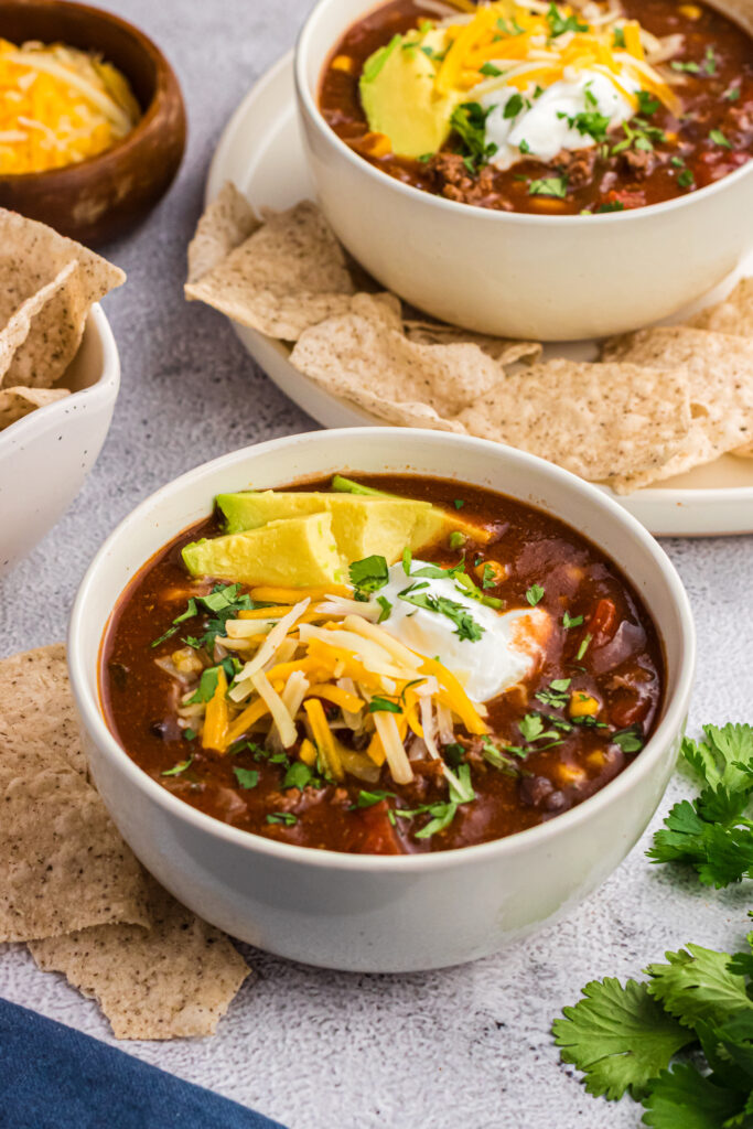 chilli topped with cheese in a white bowl