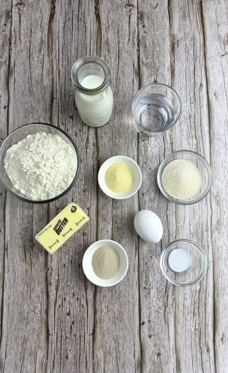 All Ingredients to make English Muffins are laid out on a wooden table.