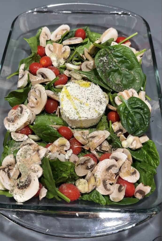 All ingredients for Boursin in glass casserole ready to back. Boursin, Spinach, Mushrooms, Tomatoes and Garlic