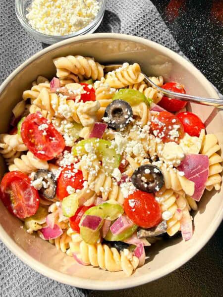 Bowl of Pasta Salad with a small bowl of Feta Cheese beside it