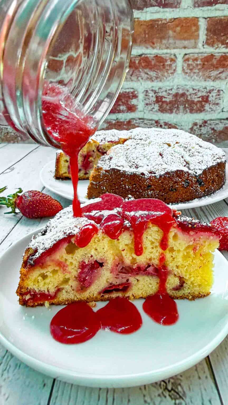 strawberry cake slice drizzled from top with strawberry sauce