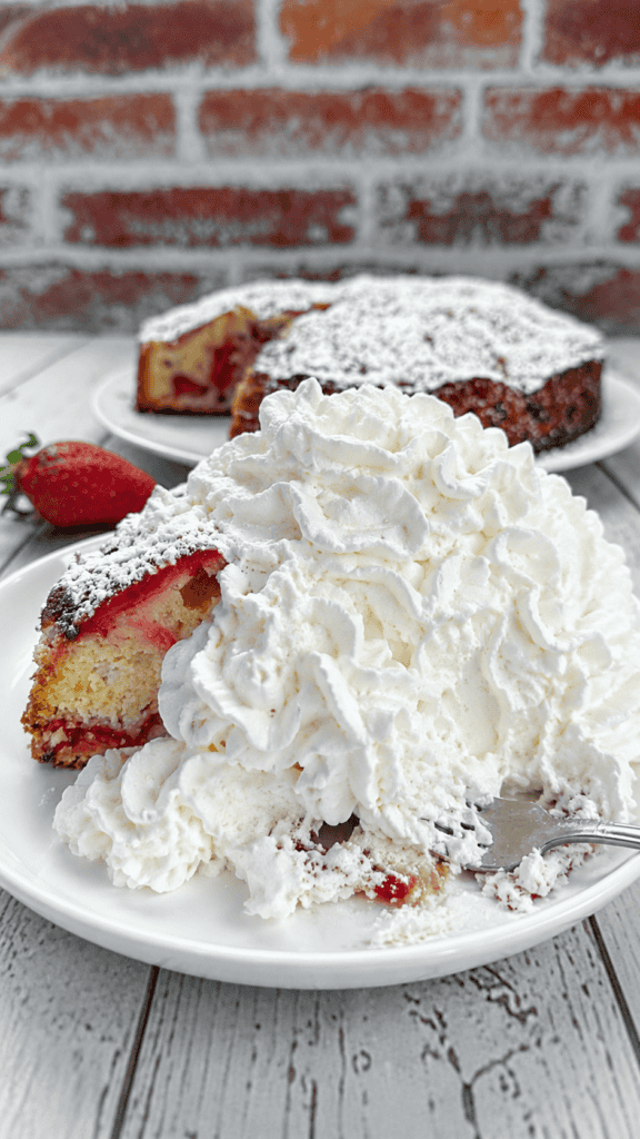 strawberry cake slice with overload of whipping cream