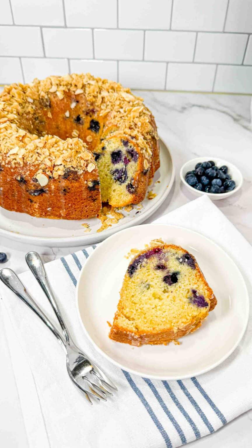 Birdseye view of blueberry bundt cake and a slice of it on a white plate