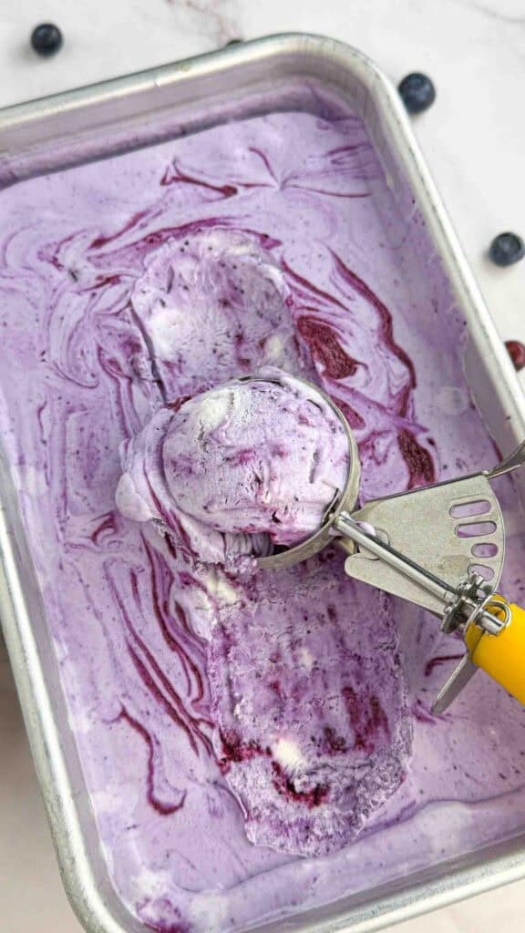 ice cream scoop in blueberry ice cream pan
