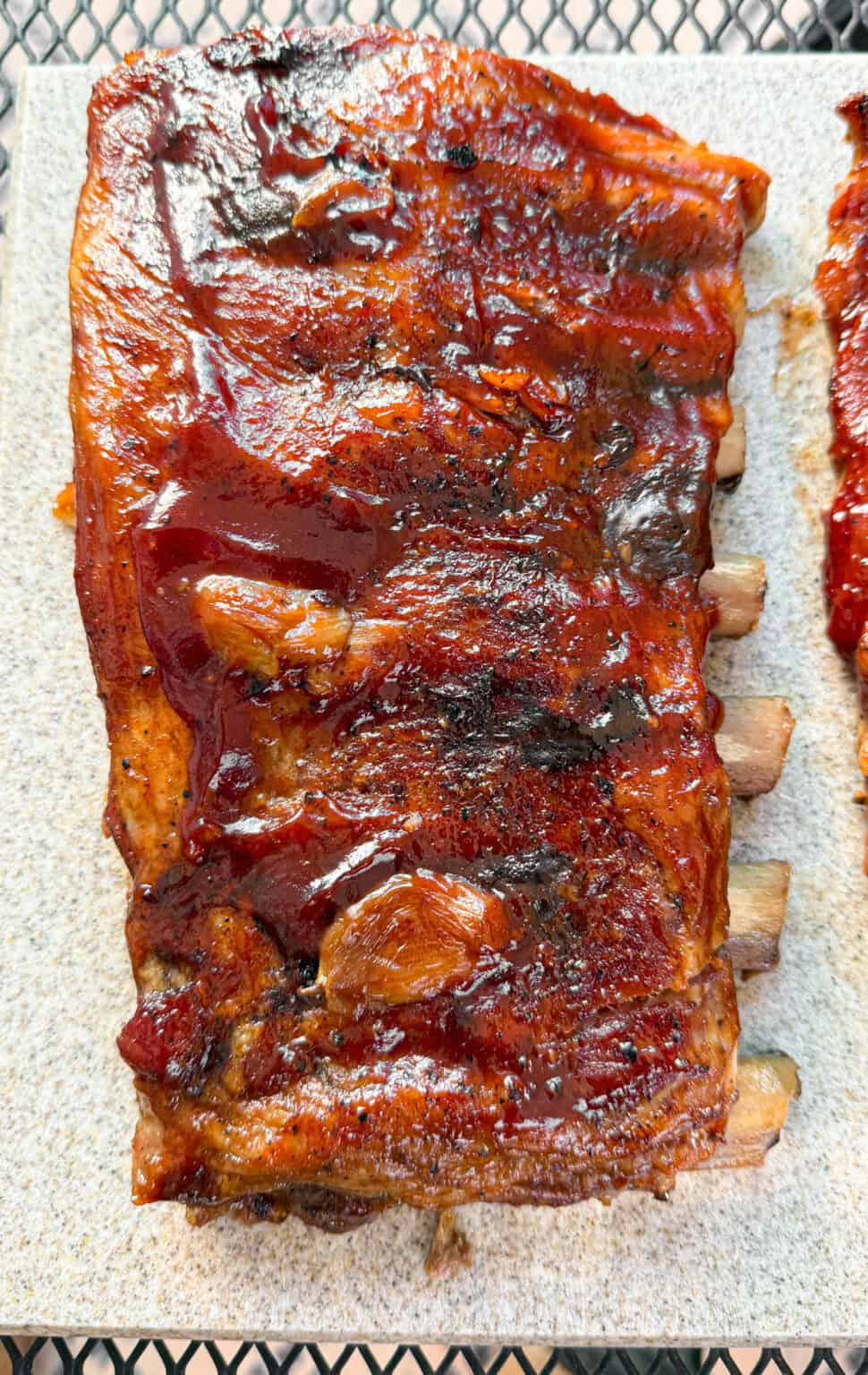 Freshly roasted Baby Back Ribs Rack topped with simmering BBQ Sauce