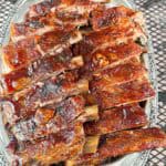 A big plate of oven baked barbecue brushed ribs so tender they fall of the bone