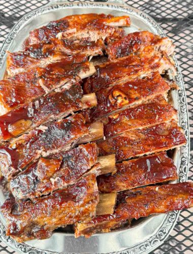 A big plate of oven baked barbecue brushed ribs so tender they fall of the bone