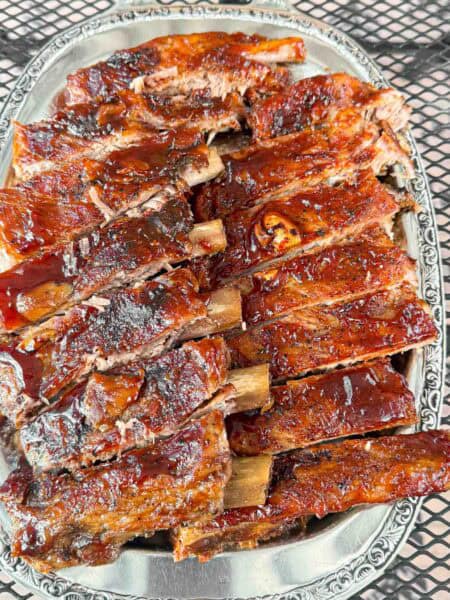 A big plate of oven baked barbecue brushed ribs so tender they fall of the bone