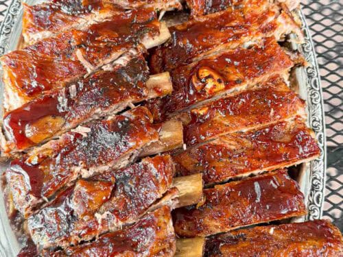 A big plate of oven baked barbecue brushed ribs so tender they fall of the bone