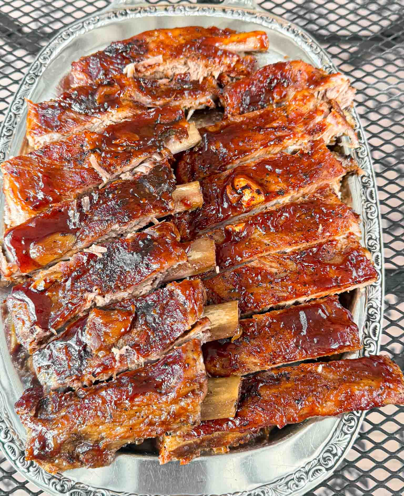A big plate of oven baked barbecue brushed ribs so tender they fall of the bone