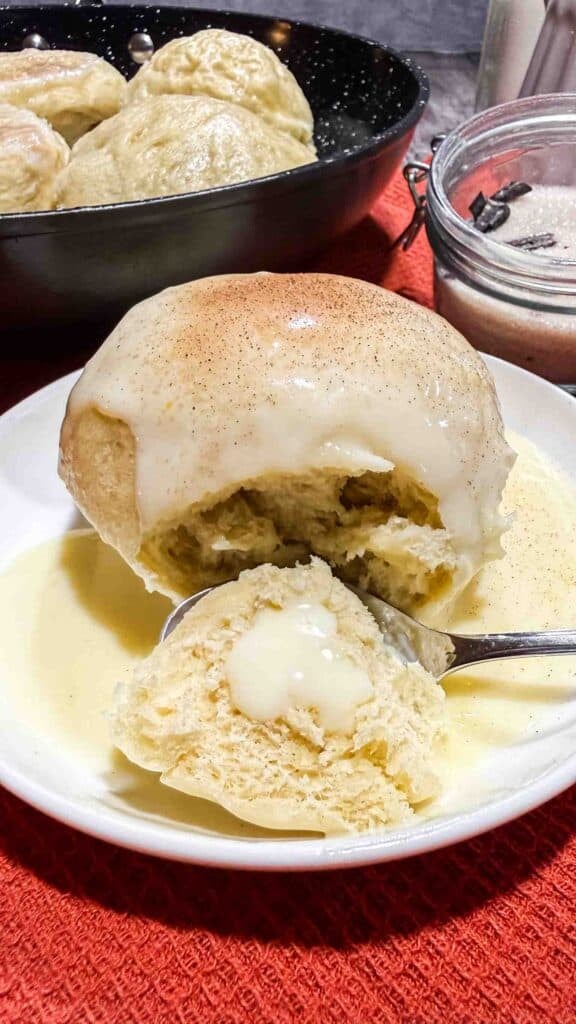 Bite of vanilla sauce coated dampfnudel on a spoon
