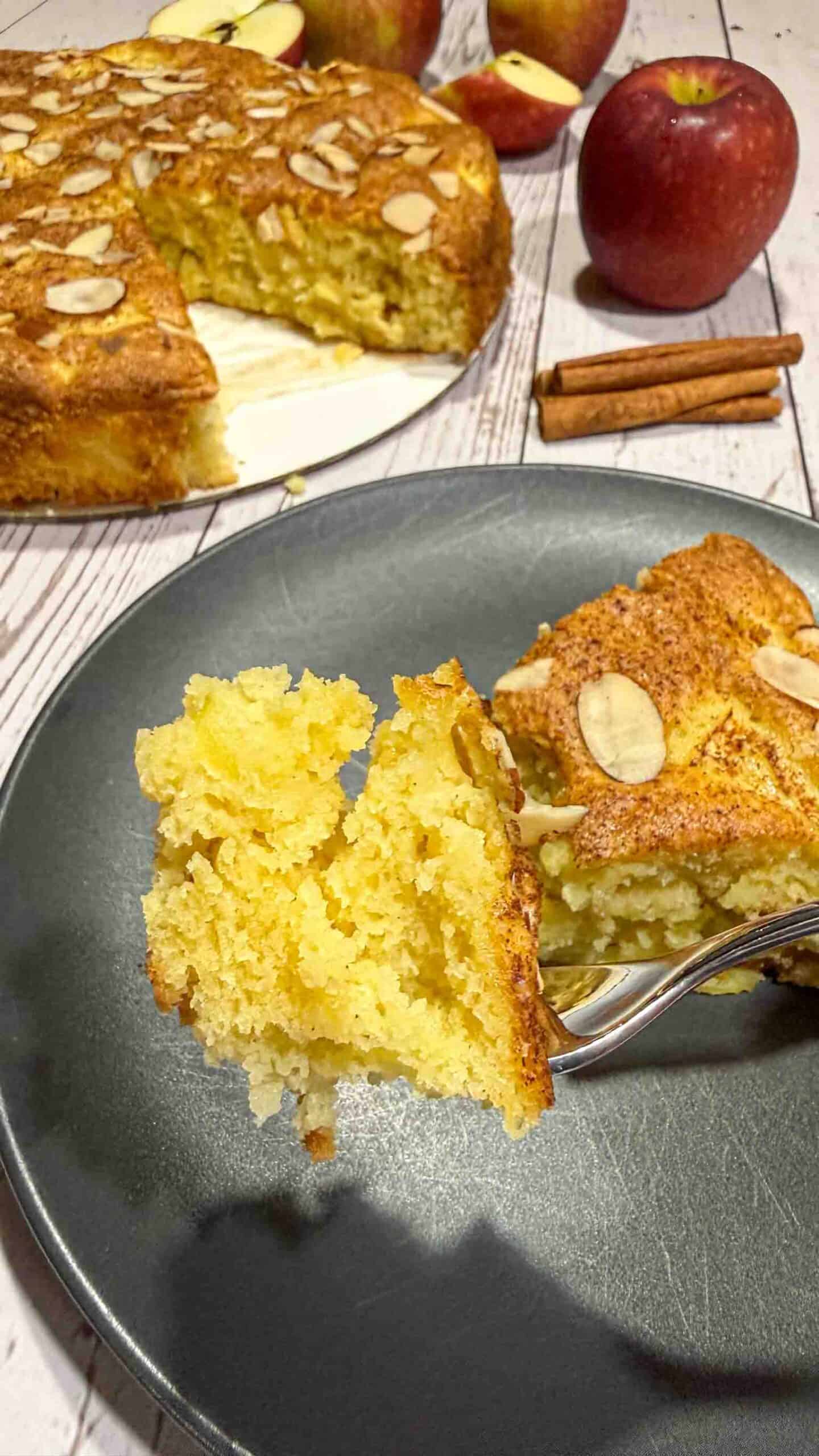 A fluffy piece of the apple cake on a fork