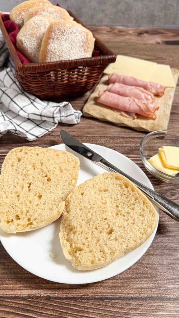 inside view of cibatta bread with ham and butter on  the side